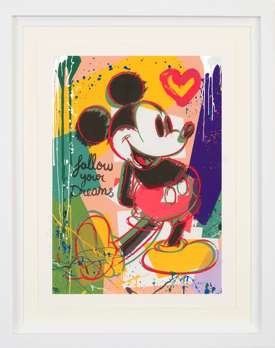 Colourful artwork by Mr. Brainwash featuring Mickey Mouse cheerfully against a vibrant abstract background of splashes and drips in yellow, pink, green, and blue. A red heart floats beside him, and the handwritten phrase ‘follow your dreams’ appears on the left.